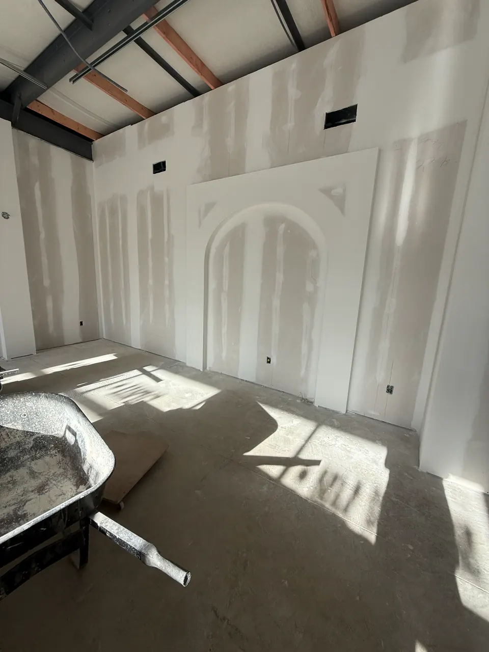 Drywall wall with decorative arched recesses and coated seams
