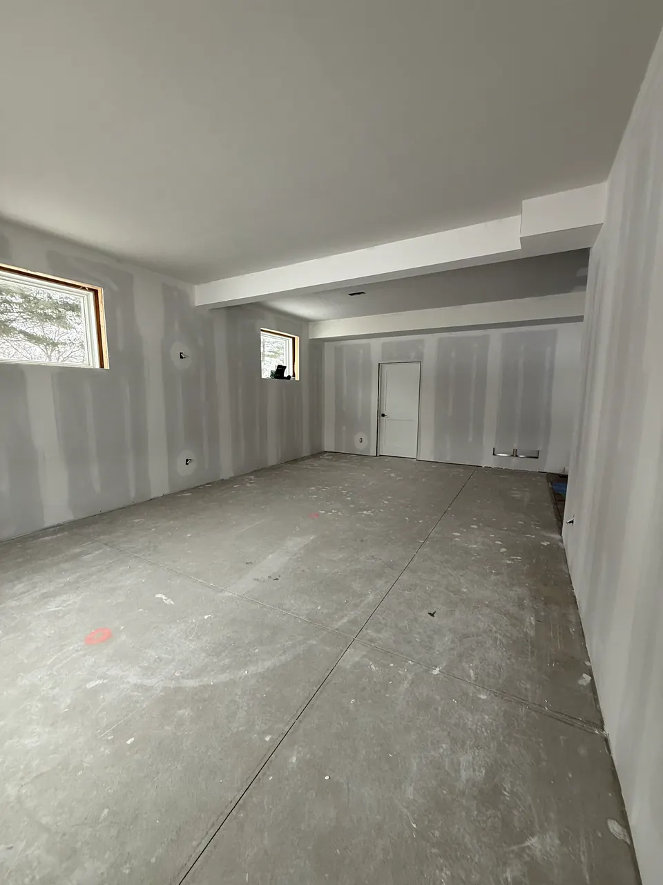 Room with coated drywall seams, ceiling beams, and door openings