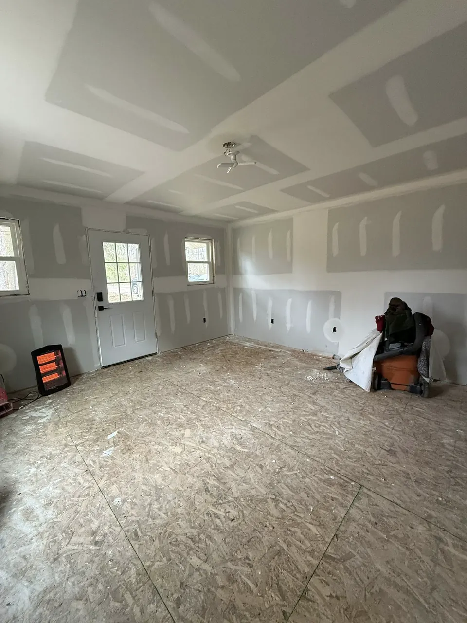 Room with coated drywall seams and exposed subfloor