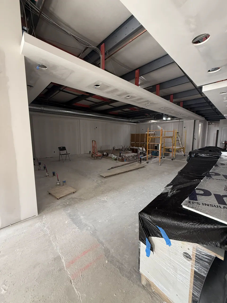 Finished white columns and soffits beneath an exposed dark ceiling
